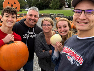 Denise anderson and her family at a pumpkin patch